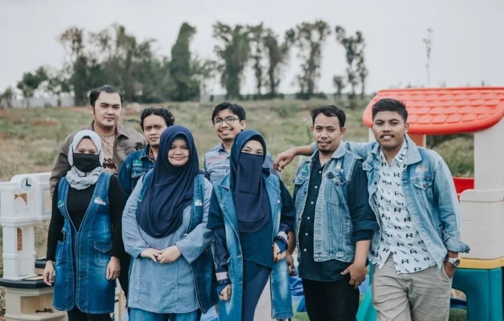 Delapan anggota tim Adha Baby Clean berfoto bersama di area bermain outdoor di Semarang